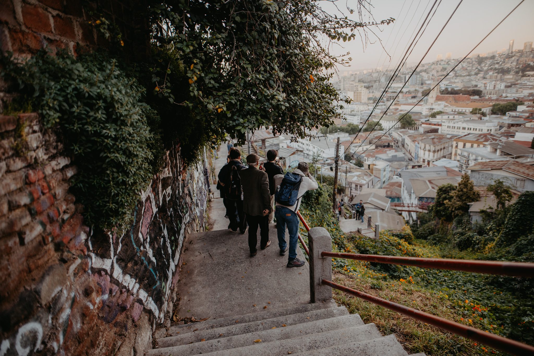 Participantes del FIFV 2025 recorren una escalera con vista a los cerros de Valparaíso.